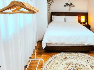een slaapkamer met een wit bed en een tapijt bij Bandal Stay in Daegu in Daegu