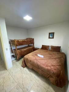 a bedroom with a large bed and a chair at Quartos Privativos Centro Gramado in Gramado