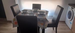 a table with chairs and a table cloth on it with a washing machine at El Rincón de Perez B in Ajo