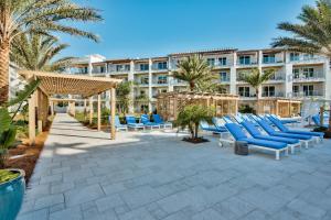 un complejo con sillones azules y un edificio en The Pointe 131, en Inlet Beach