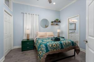 una camera da letto con un letto con una coperta verde e uno specchio di Soda Pop Cottage a Wilmington