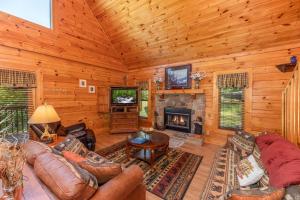 a living room with a fireplace in a log cabin at Grand View at Douglas Lake by American Patriot Getaways in Walnut Grove