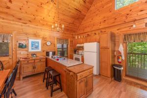 a kitchen with wooden cabinets and a white refrigerator at Grand View at Douglas Lake by American Patriot Getaways in Walnut Grove