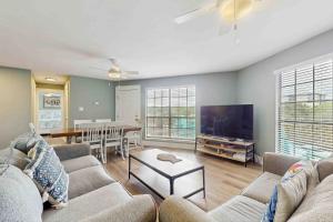 Una sala de estar con un sofá y un televisor de pantalla plana. en Sea Shell - Unit A, en Gulf Shores