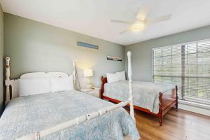 Un dormitorio con dos camas y un ventilador de techo. en Sea Shell - Unit A, en Gulf Shores