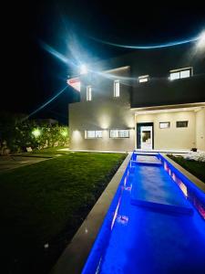 a swimming pool in front of a house at night at Villa Itran Marrakech in Aguelmous