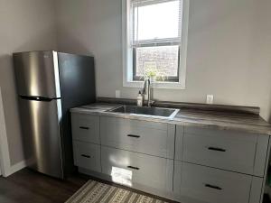 Una cocina con frigorífico de acero inoxidable y fregadero. en Downtown Minimalist Apartment, en International Falls 1 foto más