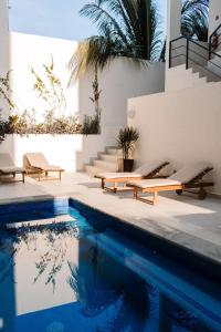 a swimming pool with benches and a swimming pool at Florence Sayulita in Sayulita