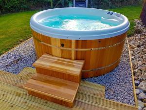 a large wooden tub with a stairs in a yard at Barley Hill Pod in Broadway
