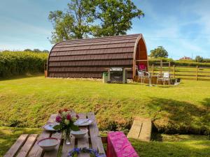a picnic table in front of a barn at Barley Hill Pod in Broadway