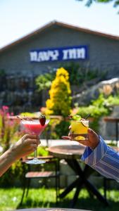 two people holding drinks at a picnic table at Navy Inn in Arnavutköy