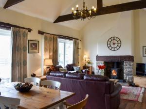 a living room with a couch and a table at High Dalton Hall Cottage in Newsham