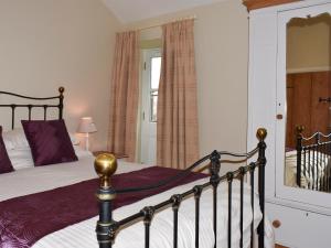 a bedroom with a bed with a wooden frame at High Dalton Hall Cottage in Newsham