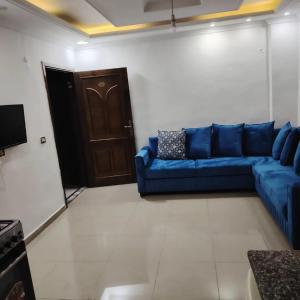 a living room with a blue couch and a door at الليث10 in Irbid