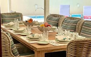 a wooden table with plates and bowls of fruit on it at ZenBreak Jack's Place 3bd in Saint Peter