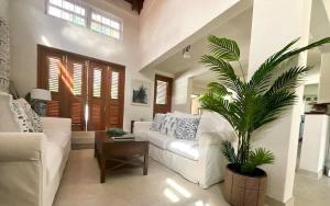 a living room with a white couch and a palm tree at ZenBreak Jack's Place 3bd in Saint Peter +20 photos