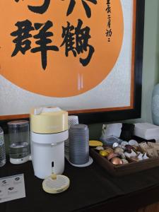 a counter with a coffee maker and a tray of food at The Gingko House in Pasadena