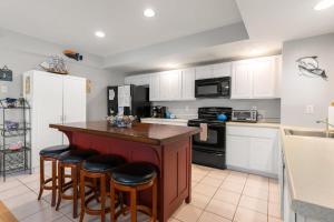 a kitchen with a island with bar stools at Stay Steps from Beach with Pool AC Parking in Hampton