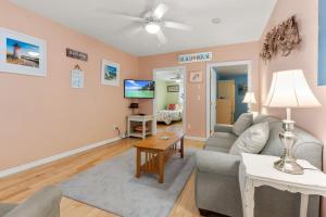 a living room with a couch and a table at Stay Steps from Beach with Pool AC Parking in Hampton