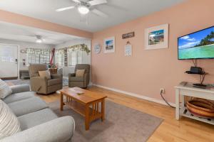 a living room with a couch and a tv at Stay Steps from Beach with Pool AC Parking in Hampton +60 photos