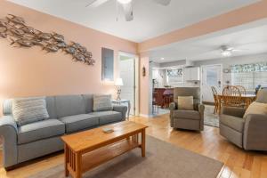 a living room with a couch and a table at Stay Steps from Beach with Pool AC Parking in Hampton