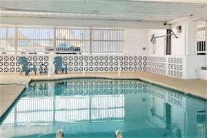 a swimming pool with two chairs in a building at Stay Steps from Beach with Pool AC Parking in Hampton