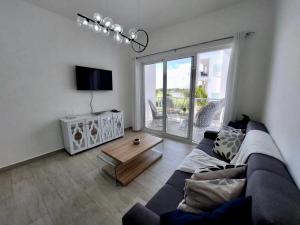 プンタ・カナにあるComfortable 1BDR in Cana Pearl with Lake/Golf Viewのソファとコーヒーテーブルのあるリビングルーム