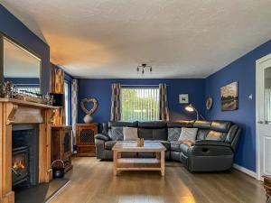 a living room with a couch and a fireplace at Rosedale in Benllech