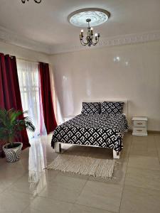 Schlafzimmer mit einem schwarzen und weißen Bett und einem Kronleuchter in der Unterkunft Private Room in Luxury Villa Secure Gated Area, Dakar in Pikine + 4 Fotos