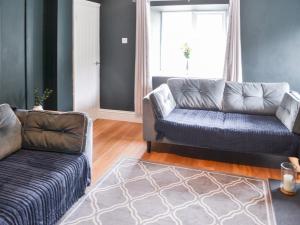 a living room with a couch and a chair at Prospect Cottage in Catton