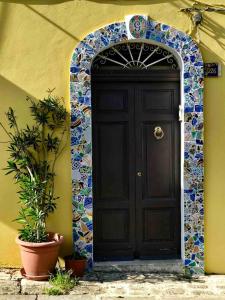 a black door on a building with a plant in front at Accommodates 5 people between Ibla and Ragusa in Ragusa