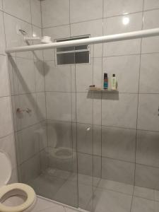 a bathroom with a glass shower stall with a toilet at Recanto da vila in Garopaba