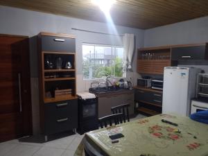 a kitchen with a table and a counter top at Recanto da vila in Garopaba