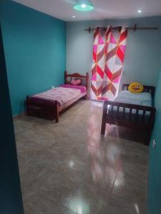 2 Betten in einem Zimmer mit blauen und rosa Wänden in der Unterkunft Casa de campo San Agustín in Cerrillos + 3 Fotos