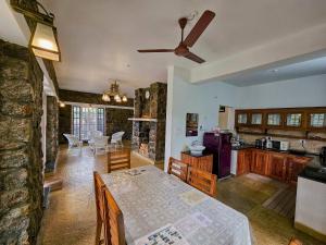 a kitchen and living room with a table and a ceiling fan at Semni Escape Plantation Bungalow-Vagamon in Vagamon +20 photos