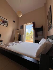 a large bed in a room with a window at Sea & Serenity - Balcony Daydreaming in Neos Marmaras