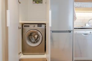 a kitchen with a washing machine in a kitchen at Chic Coastal Hideaway in Hermanus