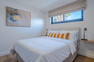 a bedroom with a white bed and a window at Chic Coastal Hideaway in Hermanus