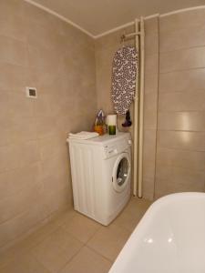 a bathroom with a washing machine and a bath tub at Luxury Spot Xanthi in Xanthi