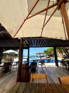 a patio with tables and chairs and a pool at Barra Bali Resort in Barra de São Miguel +30 photos