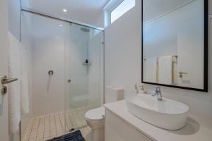 a white bathroom with a sink and a shower at Chic Coastal Hideaway in Hermanus +20 photos