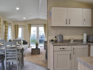 a kitchen and living room with a table and a couch at Rosie's Retreat - Uk46724 in Bridlington