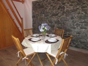a table with a vase of flowers on it at Casa Formiga in Fajã da Ovelha