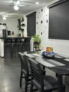 a dining room with a table and black chairs at Casa Sol y Luna in Mérida