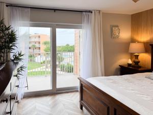 a bedroom with a bed and a large sliding glass door at Newly Renovated St Augustine Beach & Tennis Club 2bed 2bath Condo w Oceanview in Saint Augustine +31 photos