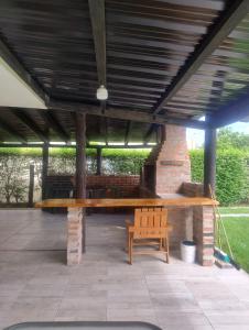 eine Holzbank unter einem Pavillon mit einem Holztisch in der Unterkunft Casa de campo San Agustín in Cerrillos