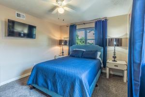 una camera da letto con un letto blu e una finestra di Spacious Home - Pet Friendly with Fenced Backyard a Del City