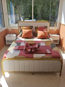 a large bed with pillows on it in a bedroom at TerraKota Cosy T2 au cœur d'Evry Courcouronnes in Evry-Courcouronnes +15 photos