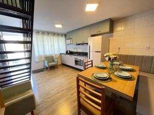 a kitchen with a wooden table with plates on it at Casa em Penha- SC in Penha +3 photos
