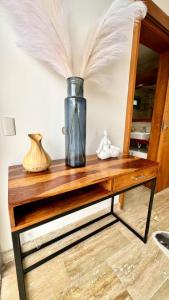 einen Tisch mit einer Vase und Federn darauf in der Unterkunft Casa Las Ballenas - 3 bedroom Las Terrenas in Las Terrenas
